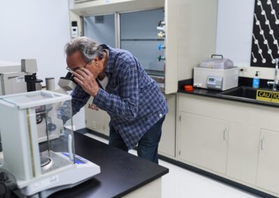 Dr. Anatoly Dritschilo views cancer cell colonies using low power microscopy.