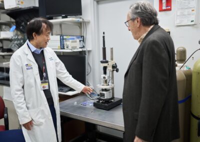 Dr. Dalong Pang (with Dr. Anatoly Dritschilo) demonstrates how atomic force microscopy applications are used to study breaks in DNA.